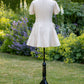 Toasted Crème Custard Dress | Short Sleeve Muslin Mini Dress With Adjustable Side Ties And Wooden Bead Accents