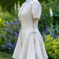 Toasted Crème Custard Dress | Short Sleeve Muslin Mini Dress With Adjustable Side Ties And Wooden Bead Accents